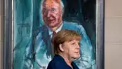 La canciller deAlemania, Angela Merkel, parada frente de un retrato del ex canciller Helmut Kohl. 