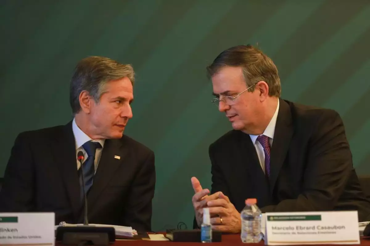El secretario de Estado de Estado de EU, Antony Blinken, y el canciller Marcelo Ebrard charlan de manera cercana, mientras se encuentrasn sentados en una mesa de trabajo.