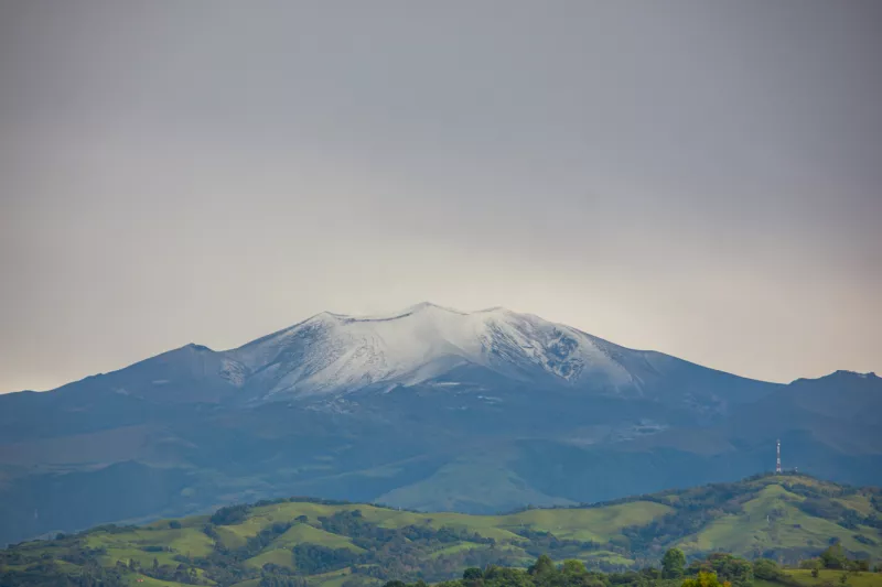 Una vista impresionante del volcán Puracé cubierto de nieve, rodeado de colinas verdes en Popayán, Cauca, Colombia. La majestuosa belleza de la naturaleza.