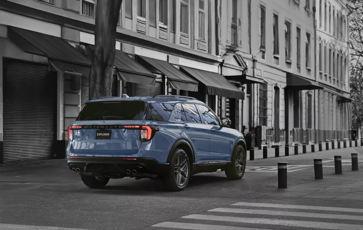 SUV Ford Explores ST modelo 2025 en color azul pálido se desplaza sobre una calle citadina, de una urbe indeterminada