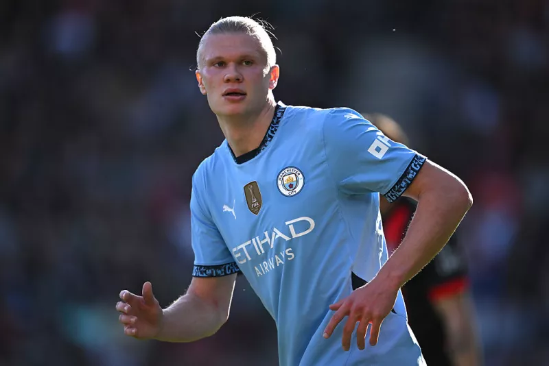 Foto a medio cuerpo de Erling Haaland con el uniforme azul del Manchester City, corriendo por el campo de juego.