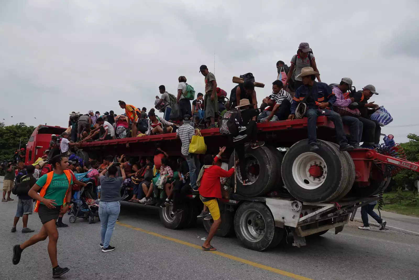 Migrantes abordan un camión de carga en el municipio de Jesús Carranza, Veracruz para trasladarse al poblado de Nuevo Morelos.