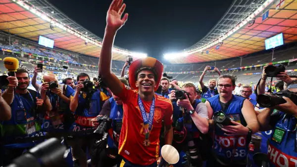 Foto de Lamine Yamal al final de la Eurocopa, sonriendo con la camiseta de la selección de España, una medalla de campeón colgando del cuello y la mano levantada en señal de victoria, rodeado de fotógrafos de todo el mundo.