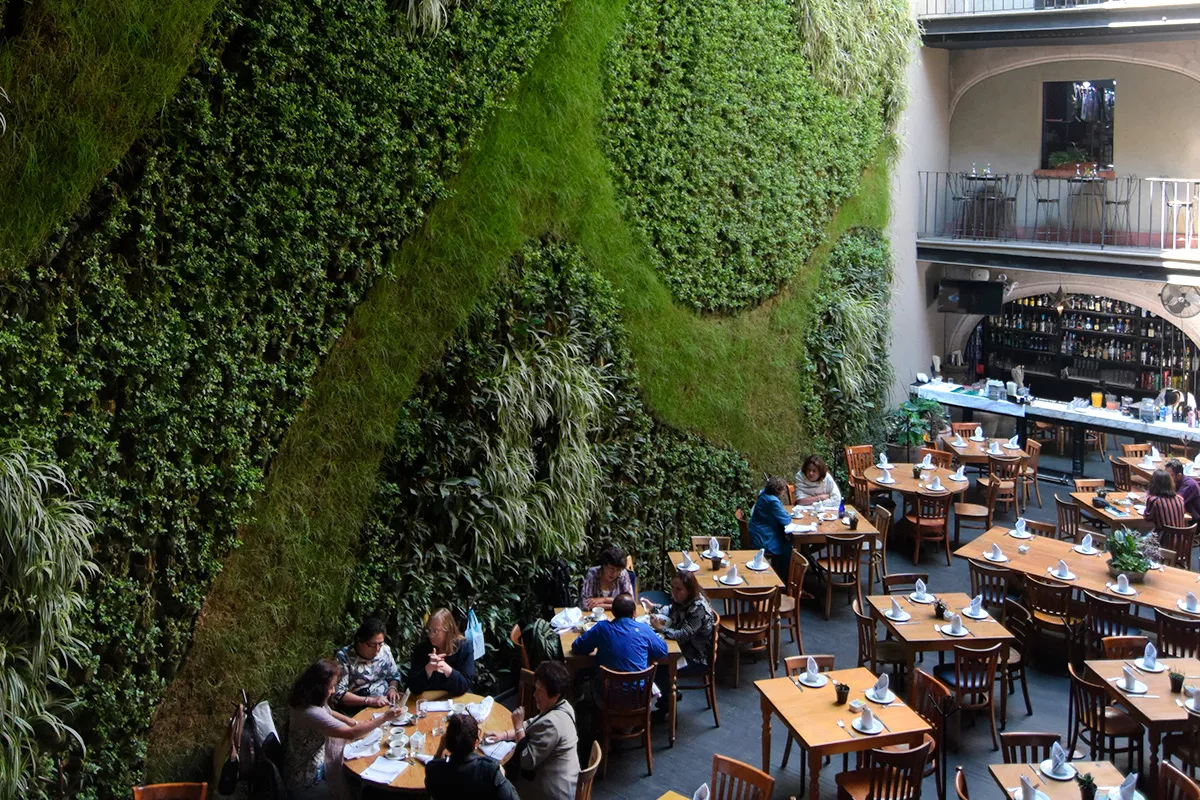 Jardín vertical y mesas con gente comiendo de The Shops at Downtown