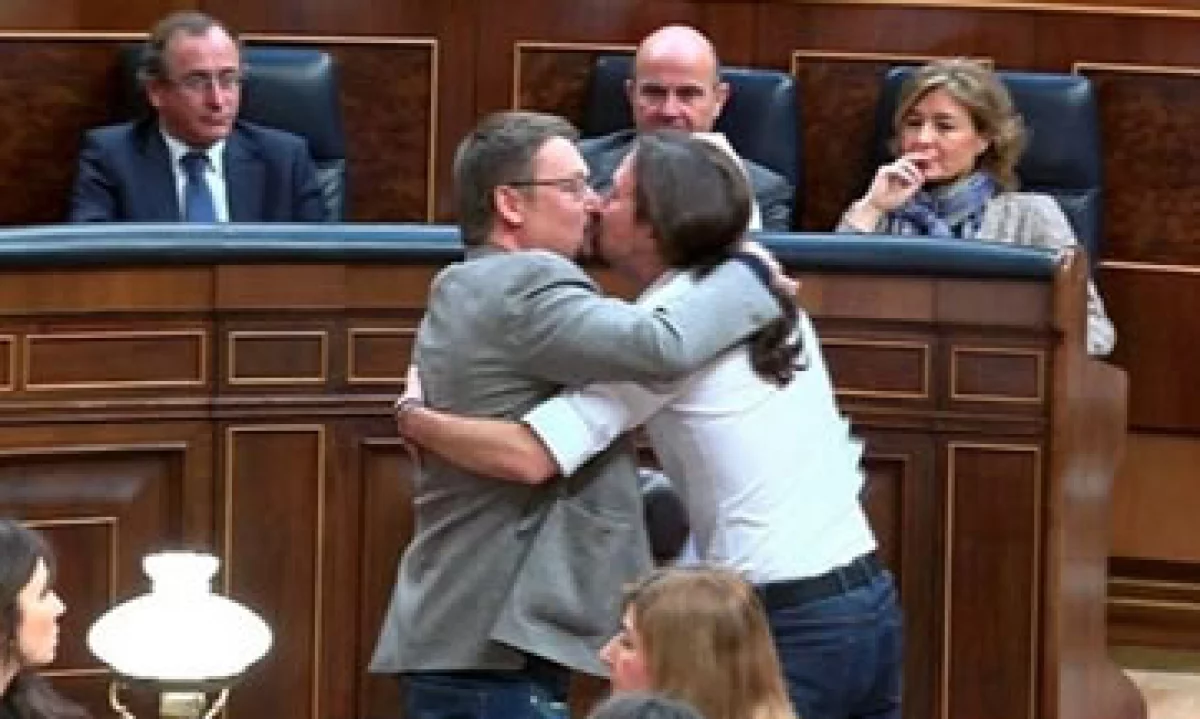 Xavier Domènech (izquierda) y Pablo Iglesias besándose en el Congreso de España tras un debate sobre una posible investidura presidencial. (Foto: Twitter/@Ambienteg)