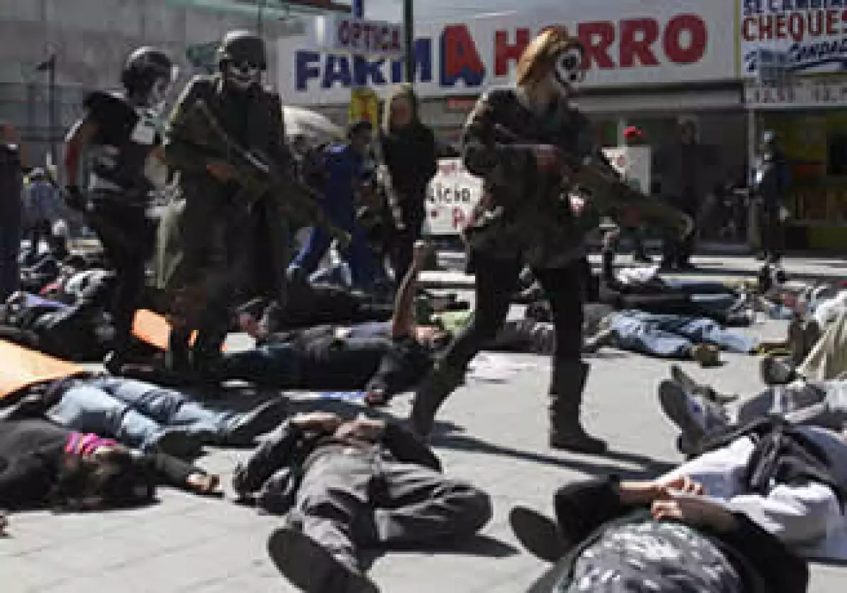 Manifestantes disfrazados de soldados y policías simulaban disparar a un grupo de jóvenes durante la protesta. (Foto: Reuters)