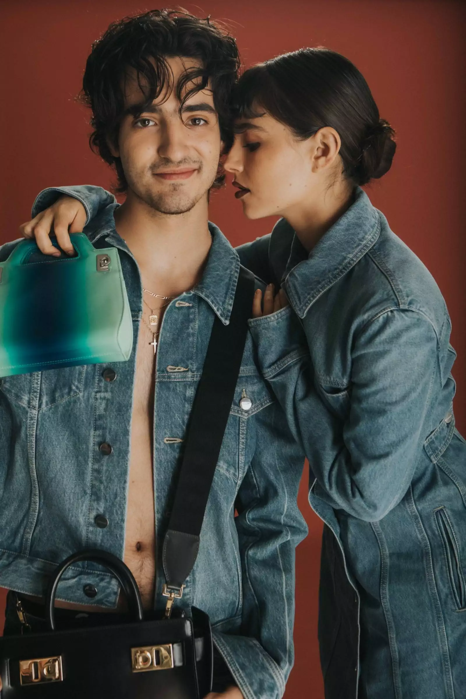 Un chico y una chica, ella lo abraza con un look en mezclilla y ambos con bolso de la colección Ferragamo Pre-fall 2023
