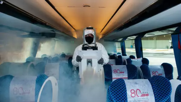 Un trabajador de la TAPO sanitiza un autobús de pasajeros.