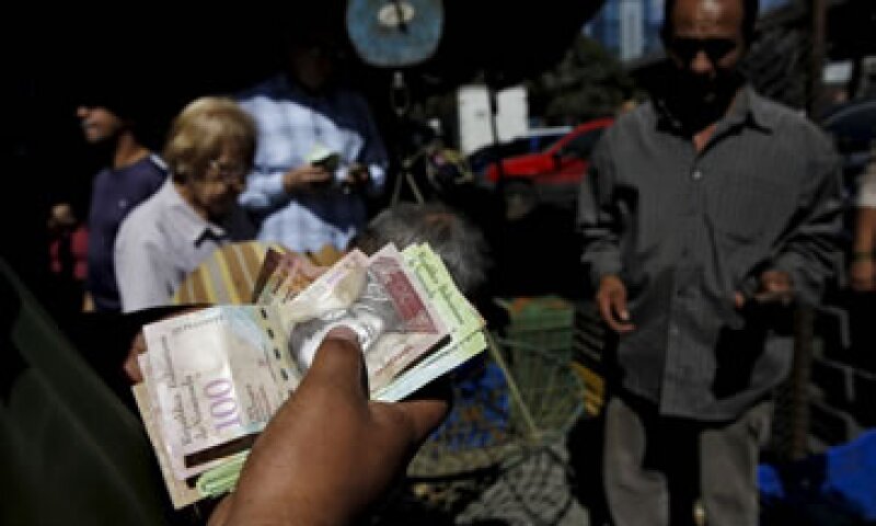 Un hombre cuenta bolívares en un mercado de vegetales en Caracas, capital de Venezuela. (Foto: Reuters )