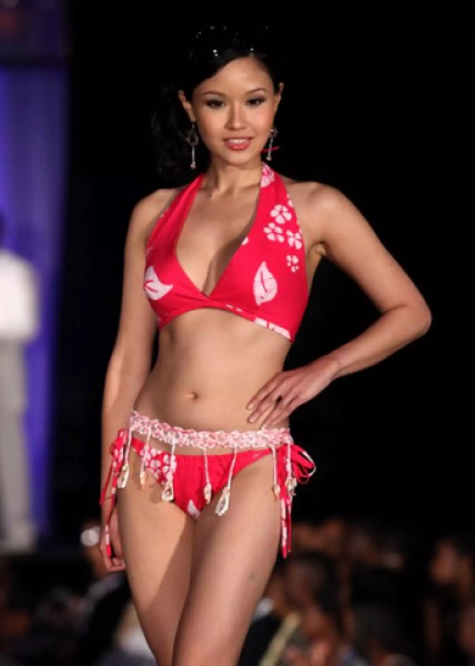 Rachel Kum, de Singapur, en un coqueto bikini rojo con un cinturón adornado con pequeños caracoles.