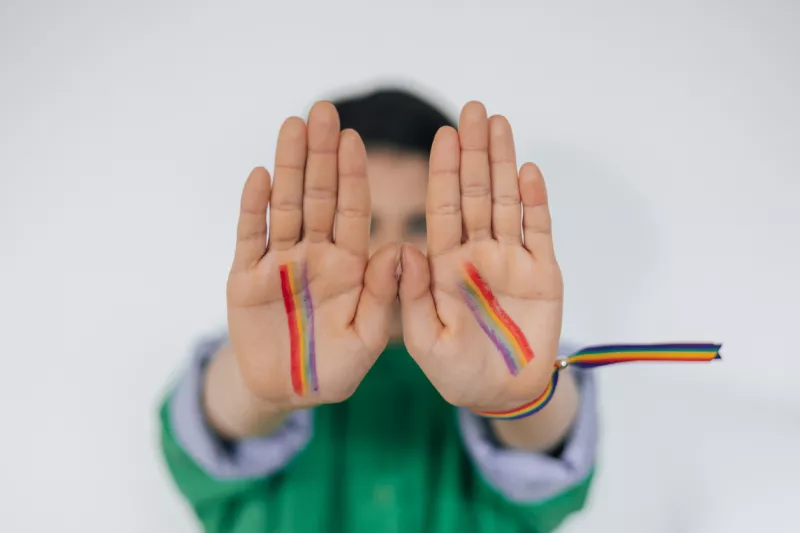 Manos de niños pintadas como bandera del arco iris LGBTQ+
