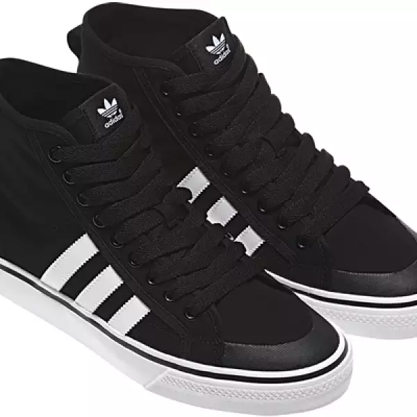 Adidas Originals mantiene un clásico de ‘los viejos tiempos’. Presenta sus tenis en negro con las tres franjas características en blanco.