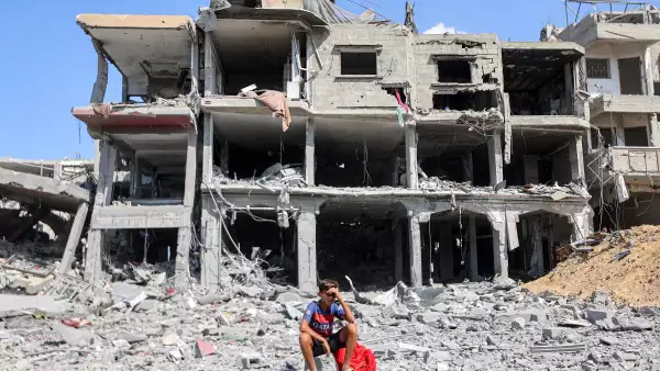 Un niño se sienta entre escombros fuera de un edificio destruido en el centro de Khan Yunis, en el sur de la Franja de Gaza, el 10 de octubre de 2025, mientras los desplazados regresan a sus hogares después de la retirada de las fuerzas israelíes. La agencia de defensa civil de Gaza dijo el 10 de octubre que las fuerzas israelíes han comenzado a retirarse de partes del territorio, particularmente en la ciudad de Gaza y Khan Yunis. Las fuerzas israelíes declararon un alto el fuego y se retiraron de algunas posiciones mientras miles de palestinos desplazados comenzaban a caminar a casa y las familias de los rehenes del 7 de octubre esperaban noticias.