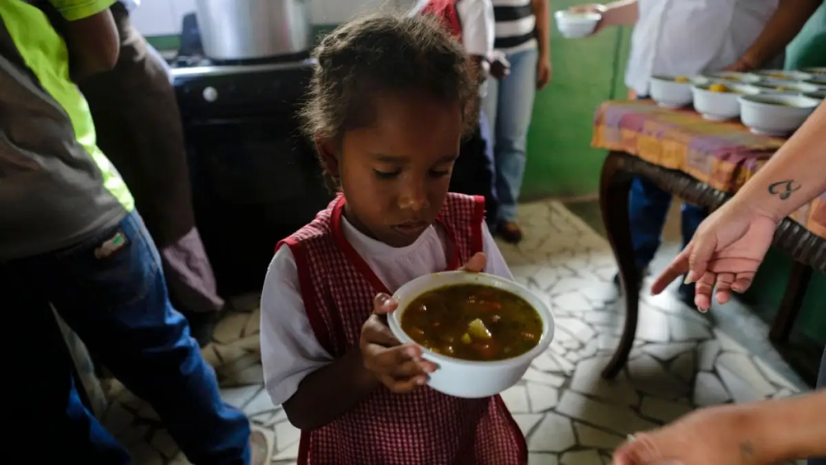 Los residentes esperan en la cola para obtener alimentos gratuitos en la despensa de alimentos dos veces por semana dirigida por La Colaborativa, una organización dirigida por Latina fundada en 1988 para servir a las comunidades de inmigrantes alrededor de Boston, en Chelsea, Massachusetts, Estados Unidos, el 23 de junio de 2023.