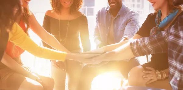Grupo de colegas felices formando un montón de manos en el cargo
