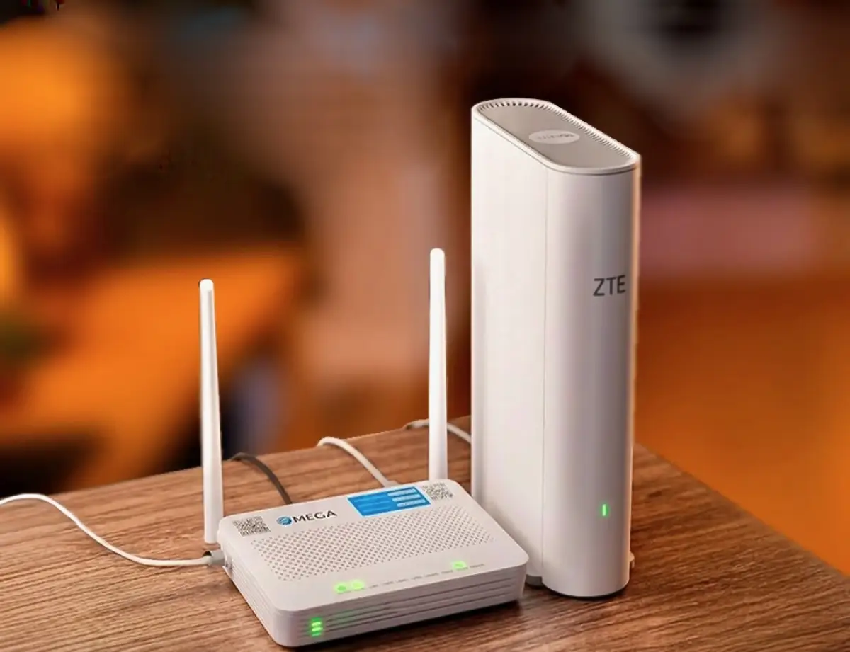 Dos moden uno con la marca de Megacable y otro de ZTE colocados en una mesa de madera color café.