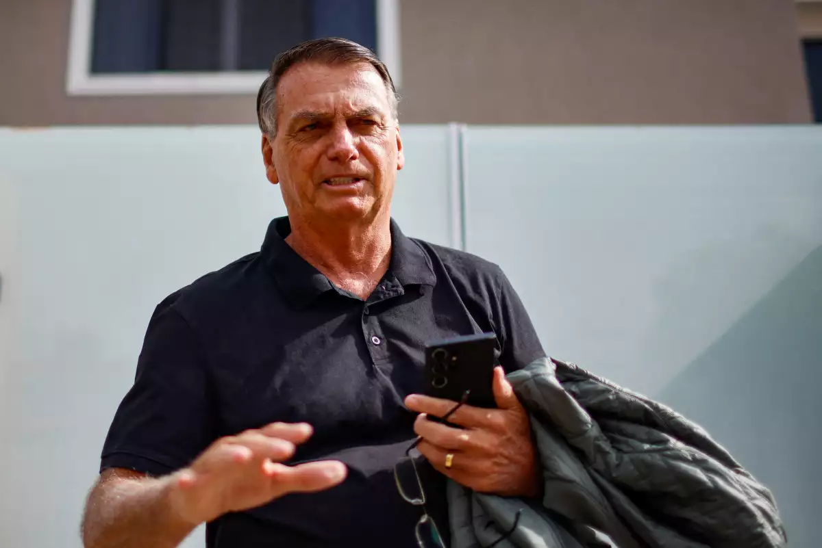 El expresidente brasileño Jair Bolsonaro hace un gesto mientras está de pie frente a su casa antes de testificar ante la Policía Federal en Brasilia, Brasil, el 22 de febrero de 2024.