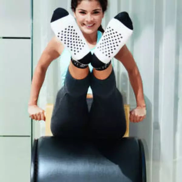 Mujer ejercitandose con pilates