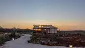 foto de un atardecer en la hacienda xtojil, en merida, en el que se ve una de las cabañas del glamping.