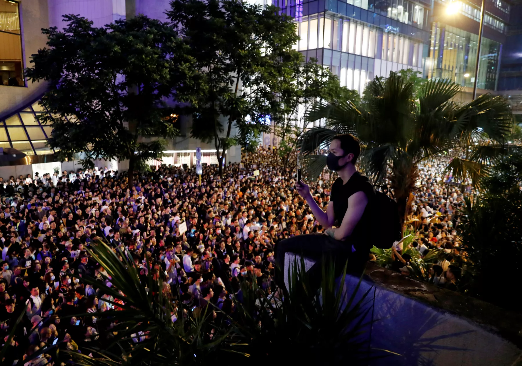 A protester sits atop an overhead bridge during a rally by civil servants to support the anti-extradition bill protest in Hong Kong