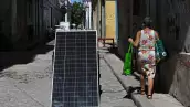 Una mujer pasa junto a un panel solar durante un corte de energía a nivel nacional en La Habana el 6 de julio de 2026.