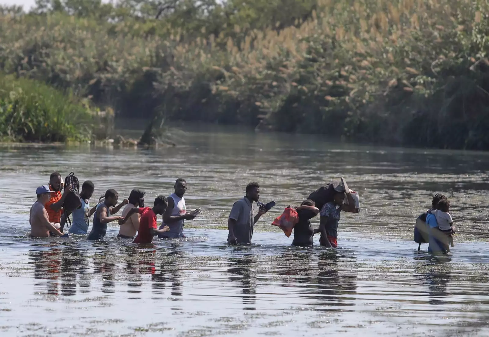 Haitianos cruzan el río Bravo del lado texano hacia suelo mexicano para conseguir comida y víveres. Los migrantes permanecen desde hace varios días en un campamento instalado de lado estadounidense en espera de que aquella nación les brinde asilo político.