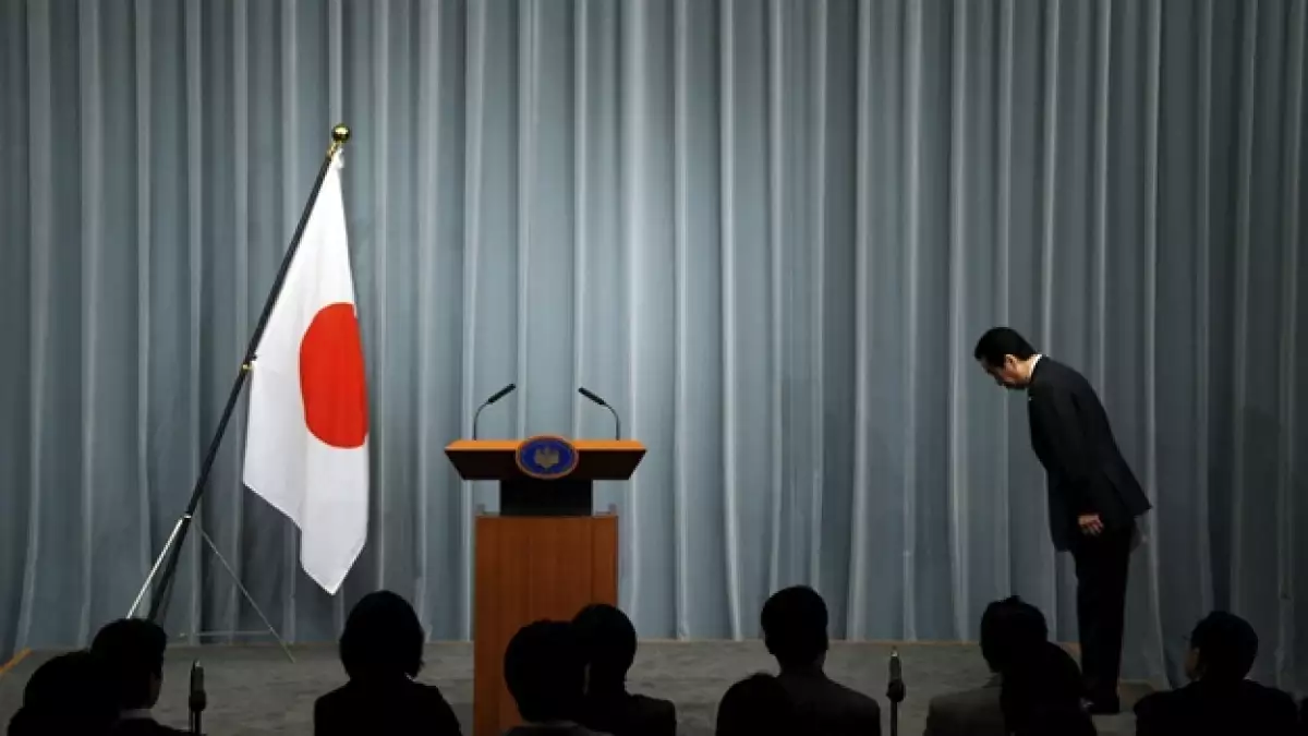 primer ministro hace una reverencia a la bandera de japon