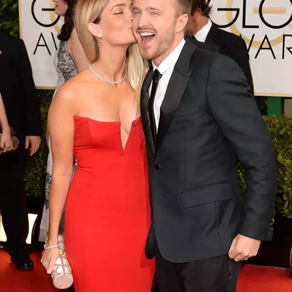 No es precisamente un beso como tal, pero al actor Aaron Paul seguro le encantó esta tierna muestra de cariño de su esposa en la alfombra roja de los Golden Globe.