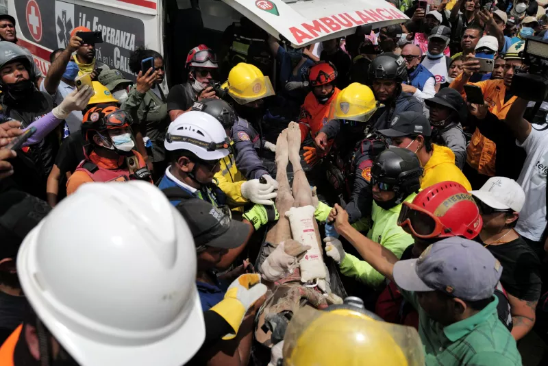 Los rescatistas llevan a una persona después de ser sacado vivo de los escombros de un edificio derrumbado en Caraballeda, estado de La Guaira, Venezuela, el 28 de junio de 2026, después de terremotos.