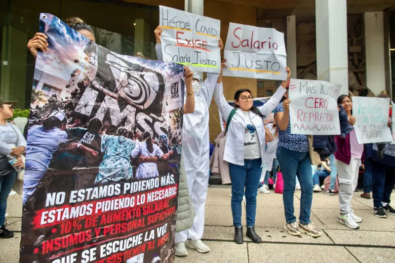 Un grupo de trabajadores sindicalizados del IMSS protesta afuera de las oficias centrales del Instituto en Paseo de la Reforma, en Ciudad de México, con cárteles que exigen salario justo, el 10 de octubre de 2026.