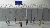 Concepto de crisis de refugiados de la Unión Europea. Personas delante de un muro fronterizo con una bandera de la UE. (Imagen principal del artículo web 'Al igual que Estados Unidos, Europa también endurece sus políticas migratorias'). 