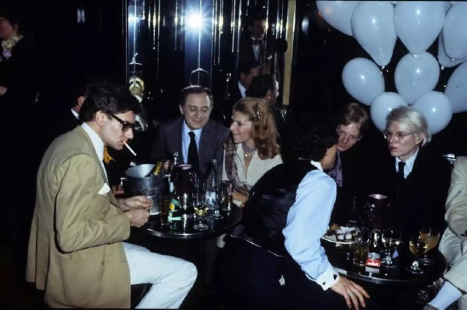 El diseñador francés Yves Saint Laurent, Pierre Berger y Andy Warhol en una fiesta en Le Palace en 1977, en Paris.