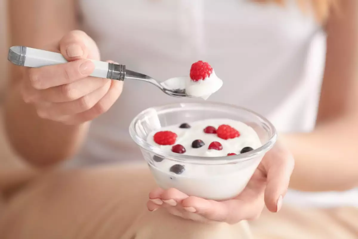 Young woman eating yogurt, closeup