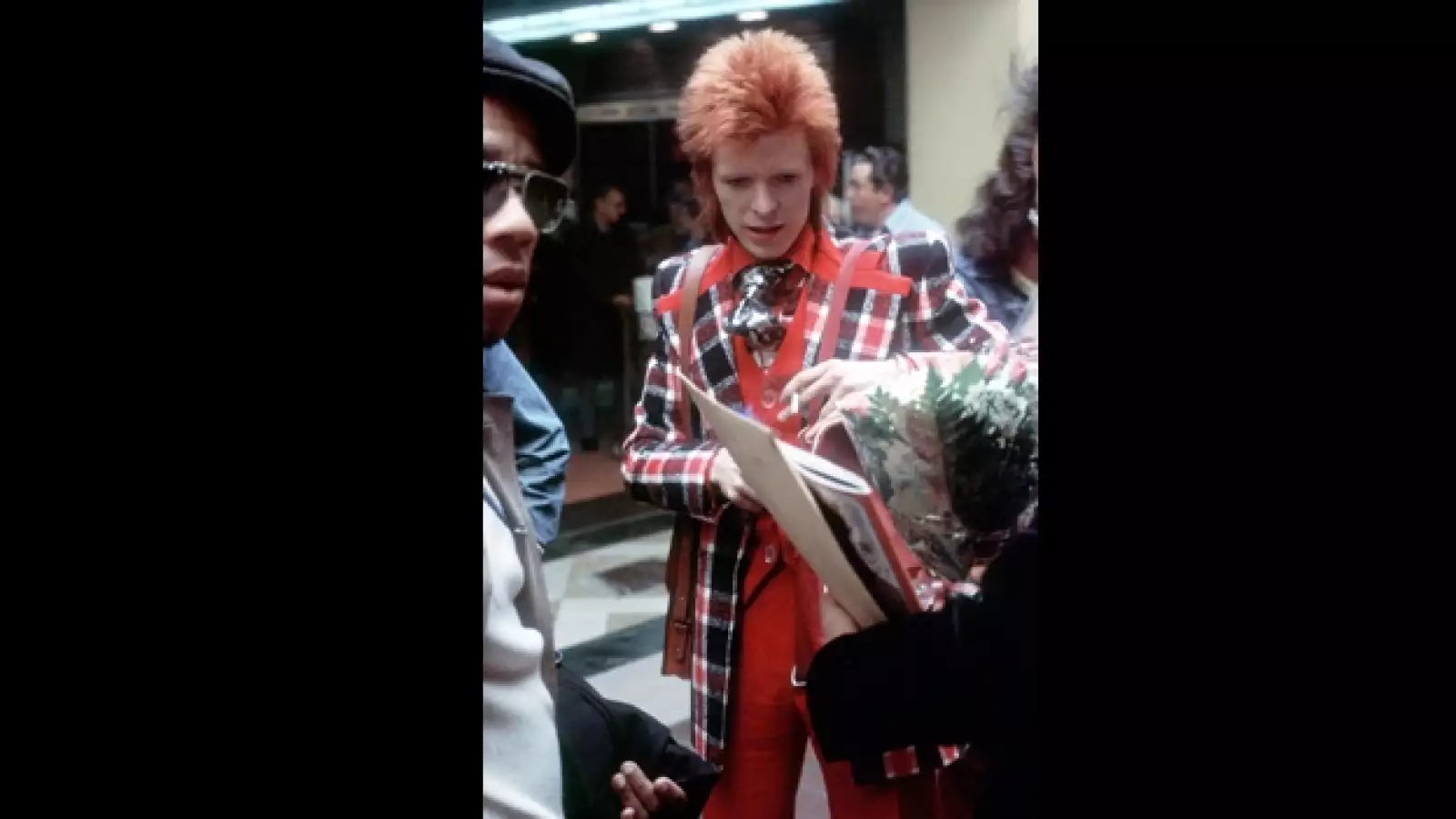 bowie firma un autografo con la mano izquierda en 1973