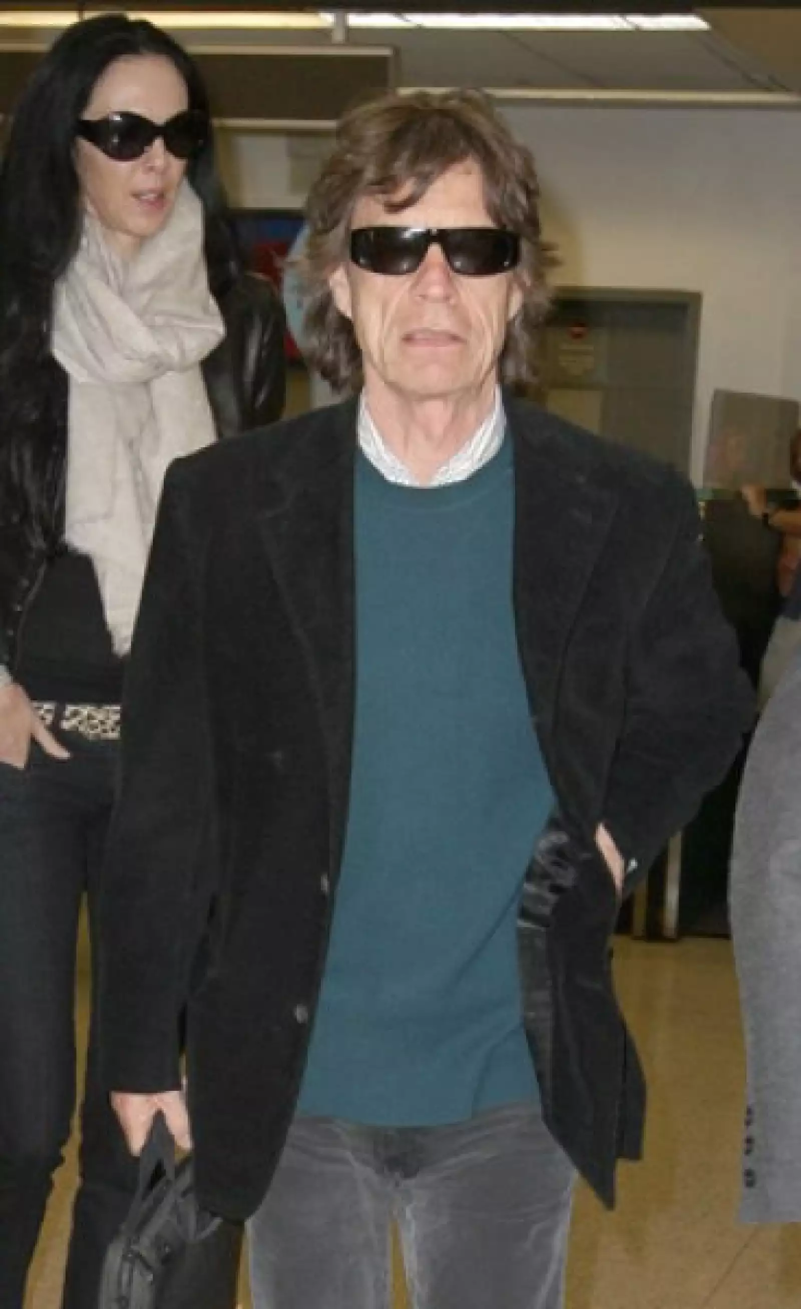 Mick Jagger llega con su novia, Lawren Scott, al Aeropuerto Internacional de Miami, Florida.
