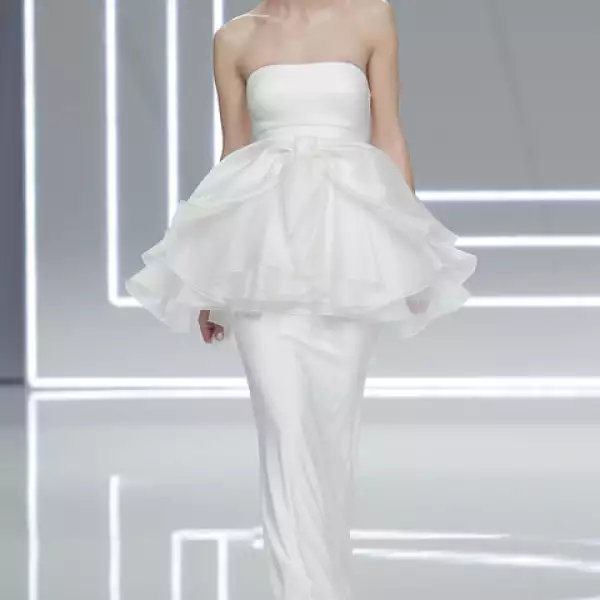 Vestido Niara de crepe de seda con escote palabra de honor y sobrefalda de organza de seda con acabados de vainica y lazo tulipan de organza de seda.