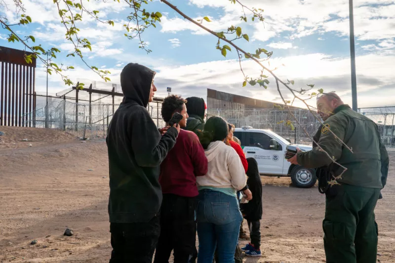 Un grupo de migrantes espera ser procesado después de cruzar el río Grande el 2 de abril de 2024 en El Paso, Texas. La semana pasada, cientos de migrantes que buscaban asilo se enfrentaron con los guardias nacionales de Texas mientras esperaban entregarse a los agentes de la patrulla fronteriza para su procesamiento.