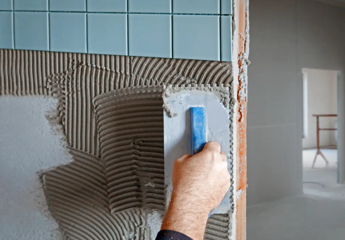 Tiler making new facing on the wall