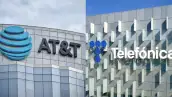 Dos edificios grises en donde uno tiene el logo de AT&T y otro  de Telefónica. 