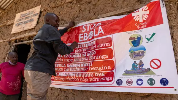 Un hombre cuelga una pancarta de concienciación sobre el ébola en el campamento de Kigonze en Bunia, en el este de la República Democrática del Congo, el 28 de mayo de 2026. Un brote de fiebre hemorrágica del Ébola se está extendiendo rápidamente en el este de la República Democrática del Congo, uno de los países más pobres del mundo.