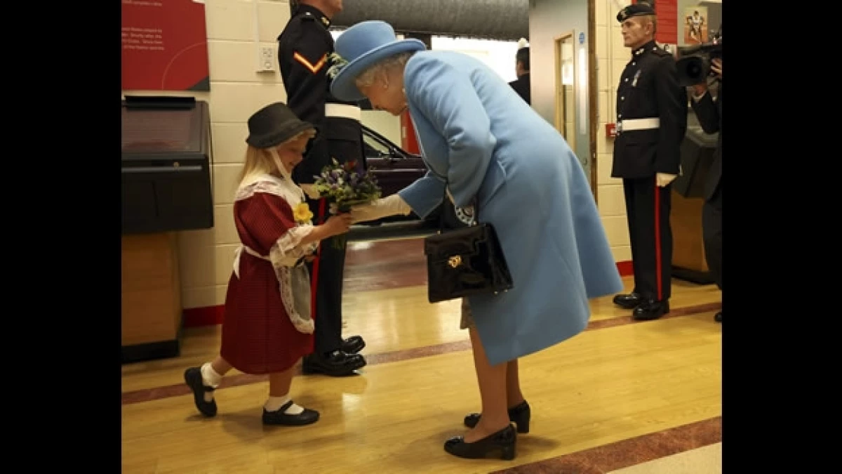 niña golpe saludo reina Isabel