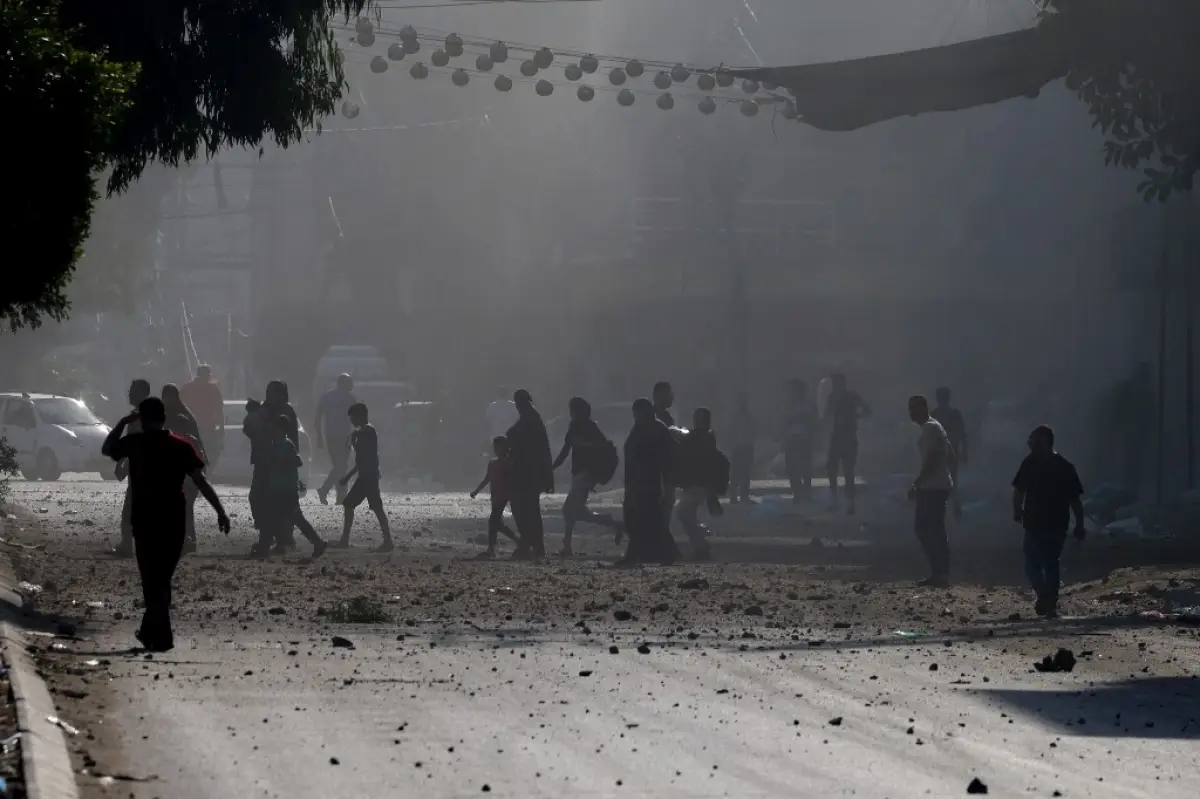 Contenido gráfico / Los palestinos evacuan un vecindario de la ciudad de Gaza durante los ataques aéreos israelíes el 11 de octubre de 2023, mientras continuaban las furiosas batallas entre Israel y el movimiento de Hamas por quinto día consecutivo
