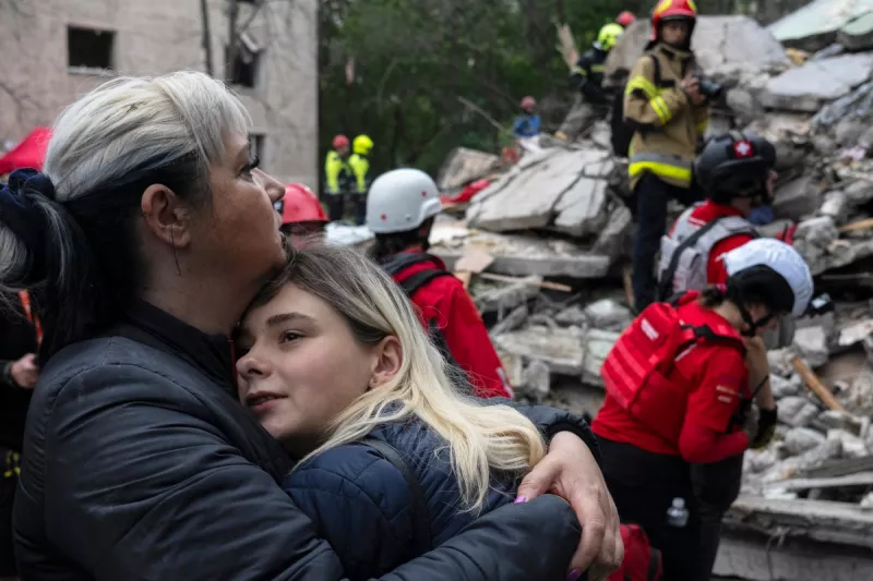 Los residentes locales se consuelan unos a otros mientras los rescatistas ucranianos trabajan entre los escombros de un edificio residencial destruido después de un ataque aéreo en Kiev el 31 de julio de 2025, en medio de la invasión rusa de Ucrania. El presidente ucraniano, el 31 de julio de 2025, instó a sus aliados a provocar un "cambio de régimen" en Rusia, horas después de que un ataque ruso con drones y misiles en Kiev matara a siete personas, incluido un niño de seis años.