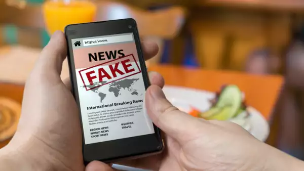 Man is holding smartphone and reading fake news on internet. Propaganda, disinformation and hoax concept.