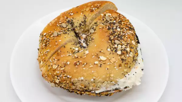 Everything Bagel with Lox Cream Cheese Spread on a White Plate with a White Background