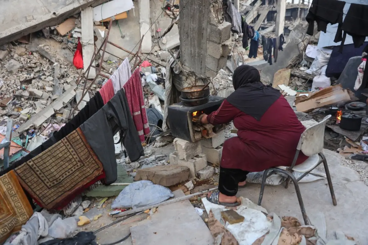 Una mujer palestina cocina en una estufa improvisada en los escombros de un edificio donde su familia se refugió en Beit Lahia, en el norte de la Franja de Gaza, antes de la comida de ruptura rápida iftar durante el mes sagrado musulmán del Ramadán el 9 de marzo de 2025. El ministro de energía de Israel dijo el 9 de marzo que había dado instrucciones para dejar de suministrar electricidad a Gaza, una semana después de que Israel bloqueara toda la ayuda en el territorio palestino devastado por la guerra.