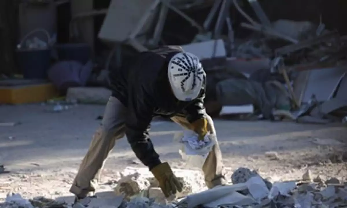 Trabajadores de Pemex reúnen documentos que sobrevivieron a la explosión del jueves. (Foto: Reuters)