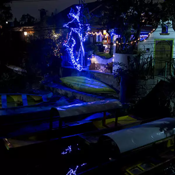 Las luces alumbran a algunas trajineras en las orillas del Lago de Xochimilco.