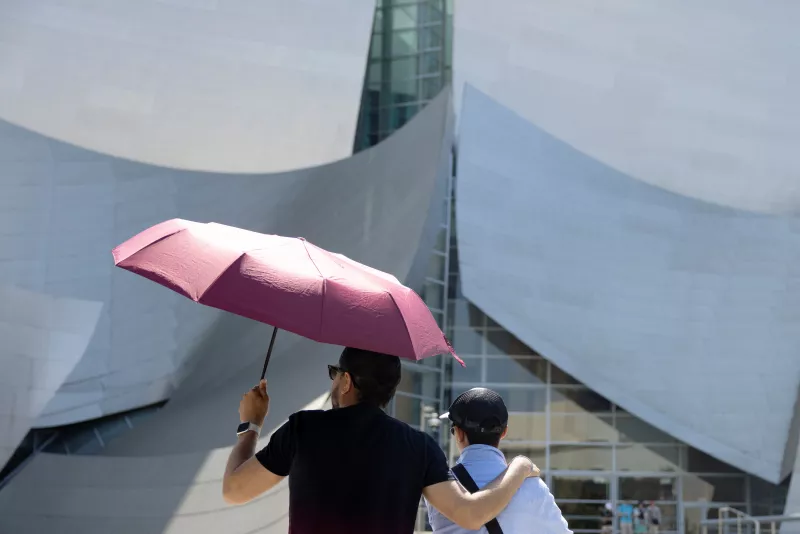 Los turistas se protegen del sol mientras miran el Walt Disney Concert Hall durante el calor en Los Ángeles, California, EE. UU., el 5 de julio de 2024.