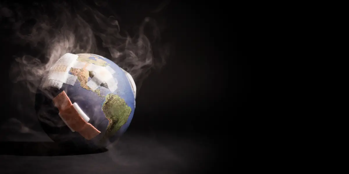 Humo blanco rodea un globo terráqueo lleno de vendajes y curitas. 